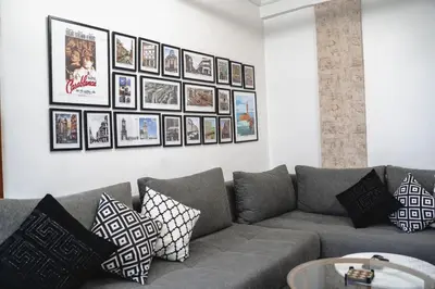 a living room with a gray couch and pictures on the wall at AnfaSuites - Le Central - Parking Free - CasaPort 5min in Casablanca