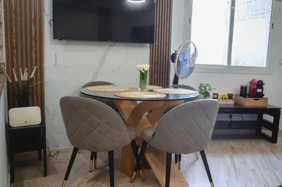 a dining room table with two chairs and a mirror at AnfaSuites - Le Central - Parking Free - CasaPort 5min in Casablanca