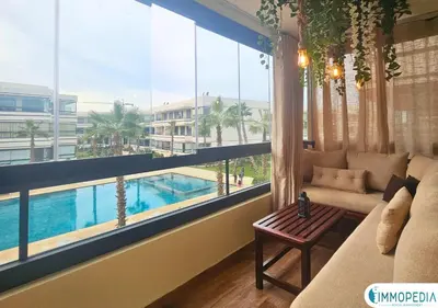 a living room with a large window overlooking a pool at Évasion de Charme à El Mansouria in Mansouria