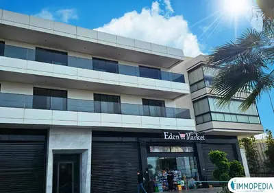 a building with a palm tree in front of it at Évasion de Charme à El Mansouria in Mansouria