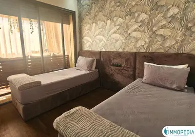 a bedroom with two beds and a wall with flowers at Évasion de Charme à El Mansouria in Mansouria