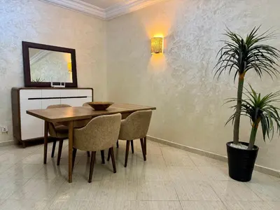 a dining room with a table and a potted plant at Casablanca Central Suites - Casa Port in Casablanca
