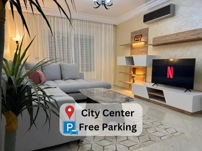 a living room with a grey couch and a tv at Casablanca Central Suites - Casa Port in Casablanca