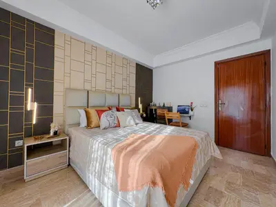 a bedroom with a large bed and a table at Charmant Appart Moderne au Cœur de Rabat avec Fibre in Rabat