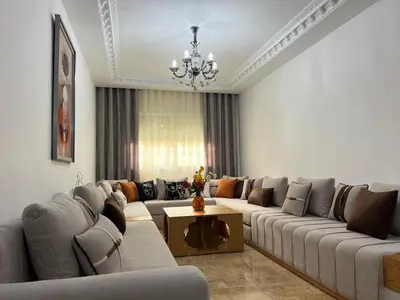 a living room with couches and a chandelier at Charmant Appart Moderne au Cœur de Rabat avec Fibre in Rabat