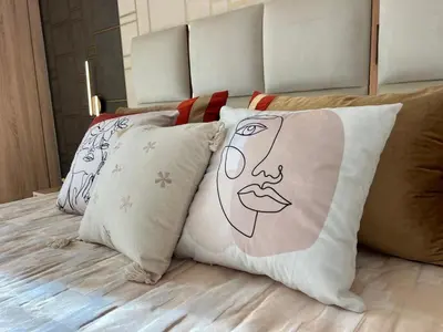 a bed with pillows with a picture of a woman at Charmant Appart Moderne au Cœur de Rabat avec Fibre in Rabat