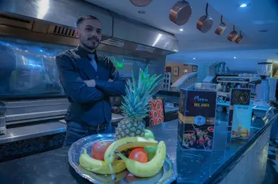 a man standing in a kitchen with a plate of fruit at Appart-Hôtel BEL ANFA in Casablanca