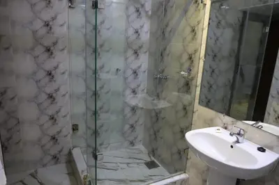a bathroom with a sink and a glass shower at Appart-Hôtel BEL ANFA in Casablanca
