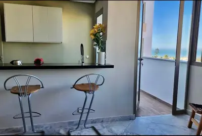 a kitchen with two stools in front of a counter at Luxurious Sea View 2 Bedroom Apartment in Anfa