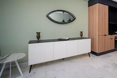 a white cabinet with a mirror on the wall at Luxueux Appartement 2 Chambres, Vue Casa Port in Casablanca