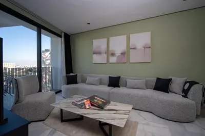 a living room with a couch and two chairs and a table at Luxueux Appartement 2 Chambres, Vue Casa Port in Casablanca