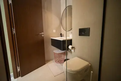 a bathroom with a sink and a toilet and a mirror at Luxueux Appartement 2 Chambres, Vue Casa Port in Casablanca