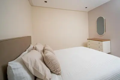 a bedroom with a bed with pillows and a mirror at Luxueux Appartement 2 Chambres, Vue Casa Port in Casablanca