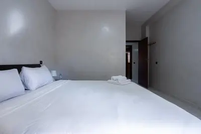 a large white bed with a phone on top of it at Appartement Cosy à Maarif, à Côté du McDonald's in Casablanca