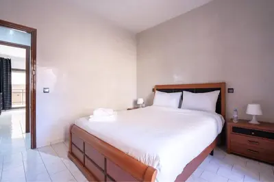 a bedroom with a large white bed and a window at Appartement Cosy à Maarif, à Côté du McDonald's in Casablanca