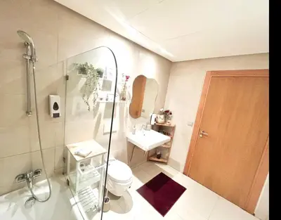 a bathroom with a toilet and a sink and a shower at Beach Front Apartement With Pool in Casablanca