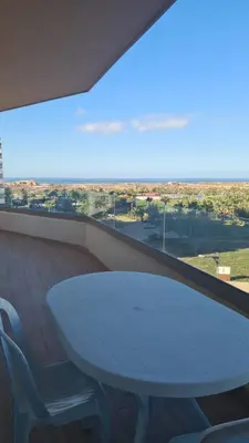 a table and chairs on a balcony with a view at Vue mer et parc, terrasse filante in Aïn Harrouda