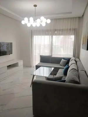 a living room with a couch and a table at Vue mer et parc, terrasse filante in Aïn Harrouda
