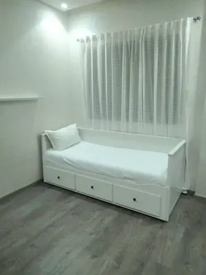 a white bed in a room with a window at Vue mer et parc, terrasse filante in Aïn Harrouda