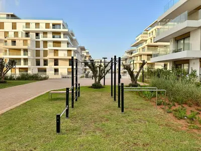 a group of poles in the grass in front of a building at Charmant studio avec vue sur mer in Rabat