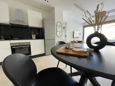 a kitchen and dining room with a black table and chairs at Charmant studio avec vue sur mer in Rabat