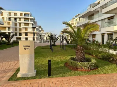 a sign with a palm tree in front of a building at Charmant studio avec vue sur mer in Rabat