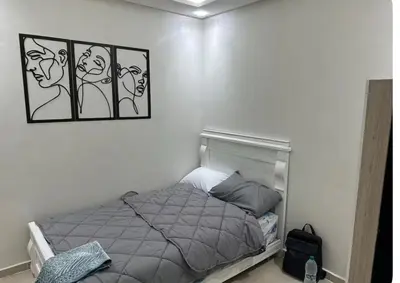 a bedroom with a bed with three pictures on the wall at Surf appart Darb in Casablanca