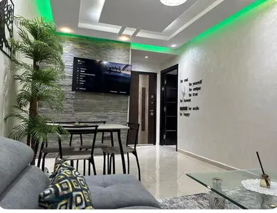 a dining room with a table and a tv on a wall at Surf appart Darb in Casablanca