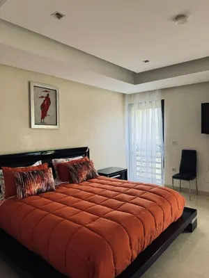 a bedroom with a large bed with an orange blanket at Mazagan private villa in El Jadida