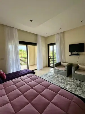 a bedroom with a large purple bed and a tv at Mazagan private villa in El Jadida