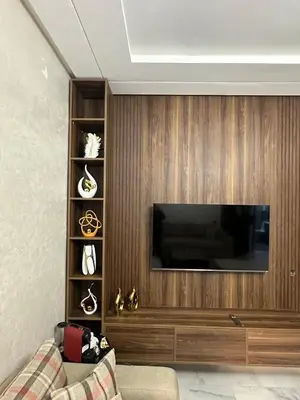 a living room with a flat screen tv on a wooden wall at Cozy appartement luxueux in Mohammedia