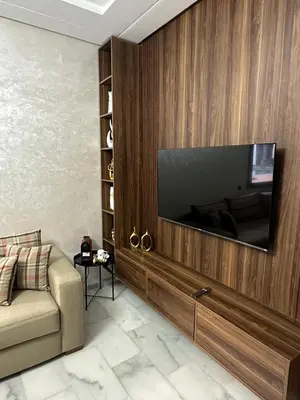a living room with a television on a wooden wall at Cozy appartement luxueux in Mohammedia