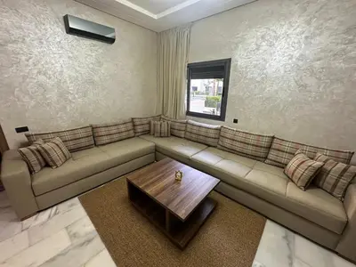 a living room with a couch and a table at Cozy appartement luxueux in Mohammedia