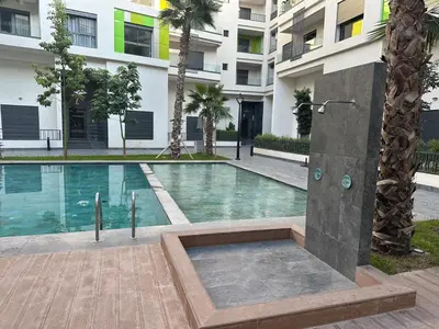 a swimming pool in front of a building at Cozy appartement luxueux in Mohammedia