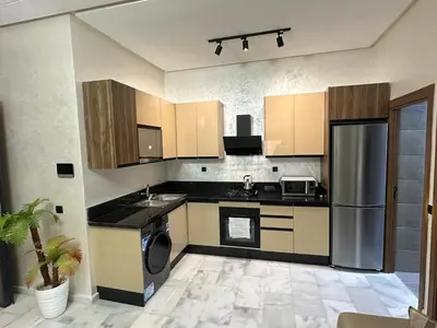 a kitchen with a refrigerator and a sink at Cozy appartement luxueux in Mohammedia