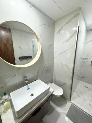 a white bathroom with a sink and a mirror at Chic Apartment in Casa Finance District -Open view - Fast WIFI in Casablanca