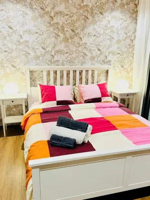 a white bed with colorful blankets and pillows on it at Chic Apartment in Casa Finance District -Open view - Fast WIFI in Casablanca
