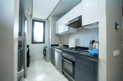 a kitchen with stainless steel appliances and a stove at Appartement luxueux avec jardin in Rabat