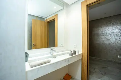 a bathroom with a sink and a mirror at Appartement luxueux avec jardin in Rabat