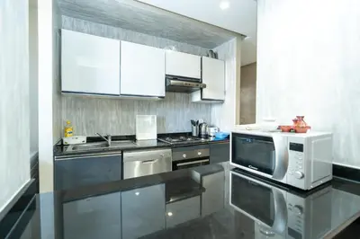 a kitchen with stainless steel appliances and white cabinets at Appartement luxueux avec jardin in Rabat