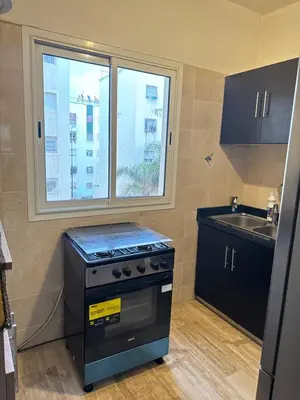 a kitchen with a stove and a sink and a window at Chill by Sea-Relaxing Stay with a View in Rabat