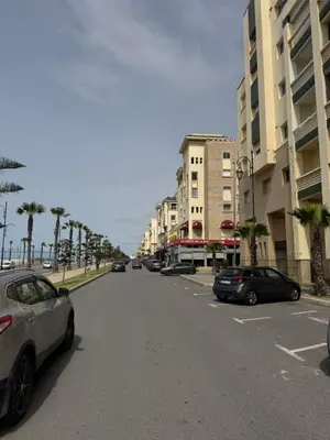 a street with cars parked on the side of a building at Chill by Sea-Relaxing Stay with a View in Rabat