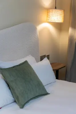 a bed with a green pillow on top of it at Modern & Chic APT Prestigia by MERAT HOME in Rabat