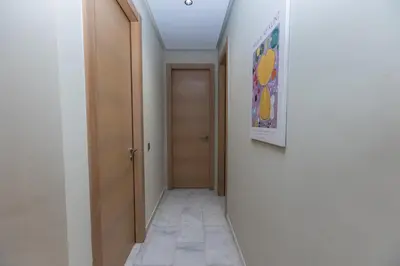 a hallway with a door and a painting on the wall at Modern & Chic APT Prestigia by MERAT HOME in Rabat