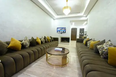 a living room with couches and a coffee table at Apartment in Dar Bouazza with Pool, Gym & Kids Playground in Dar Bouazza