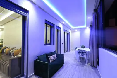 a living room with a couch and a table at Apartment in Dar Bouazza with Pool, Gym & Kids Playground in Dar Bouazza