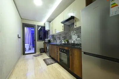 a large kitchen with a counter and a refrigerator at Apartment in Dar Bouazza with Pool, Gym & Kids Playground in Dar Bouazza