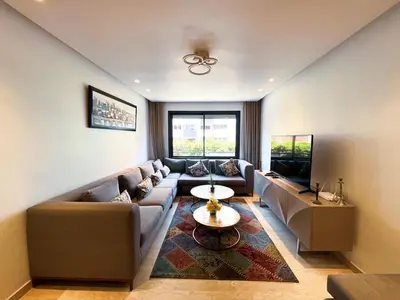 a living room with a couch and a tv at Ma Raffiné Ziraoui in Casablanca