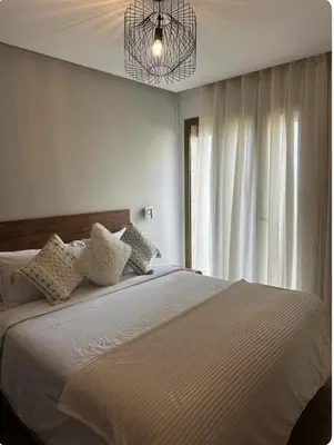 a bedroom with a large bed and a chandelier at La perle du carrousel in Rabat