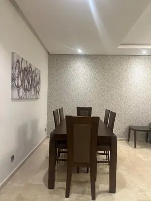 a dining room with a wooden table and chairs at Spacious Apartment 3BR by CH Hay riad, Rabat in Rabat